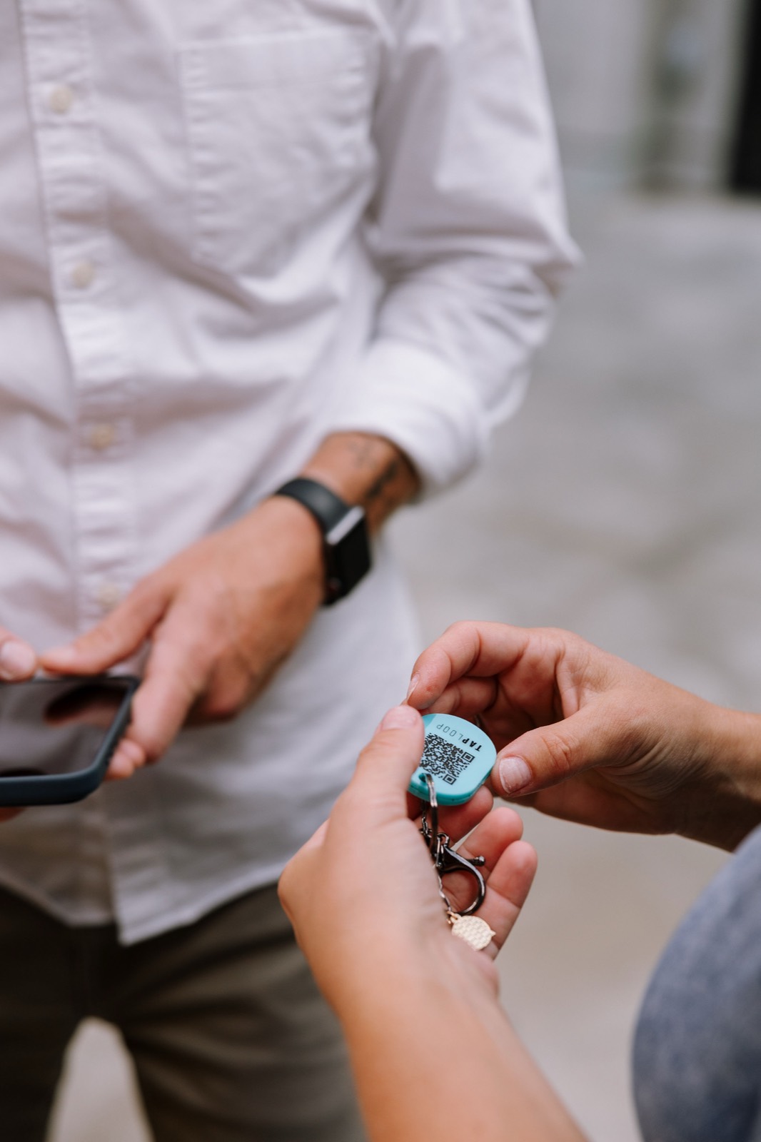 A TapLoop keychain handed to a guest at a botanical garden event — the moment a giveaway becomes a connection