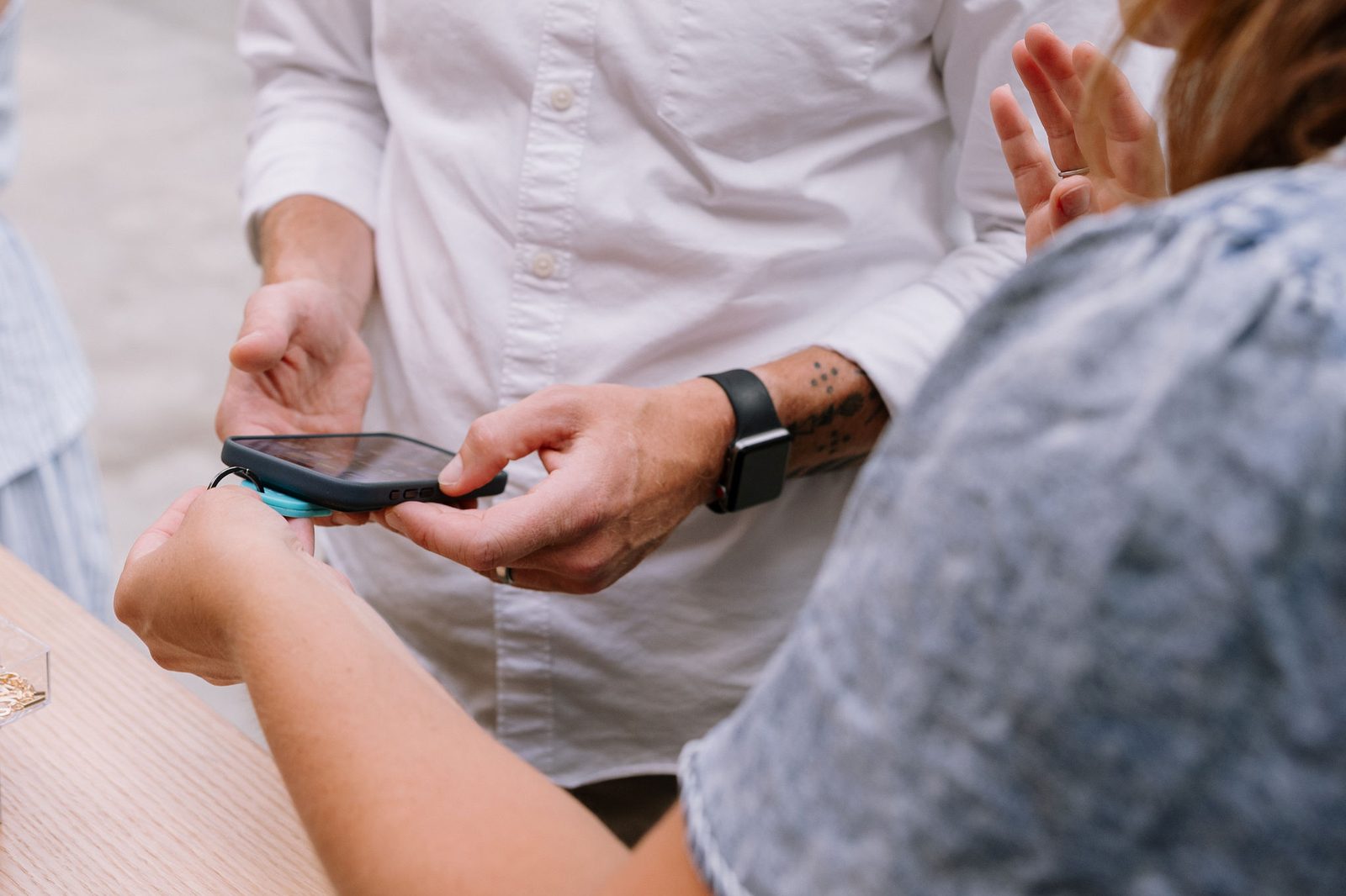 A guest tapping his phone to a TapLoop keychain to swap contact info